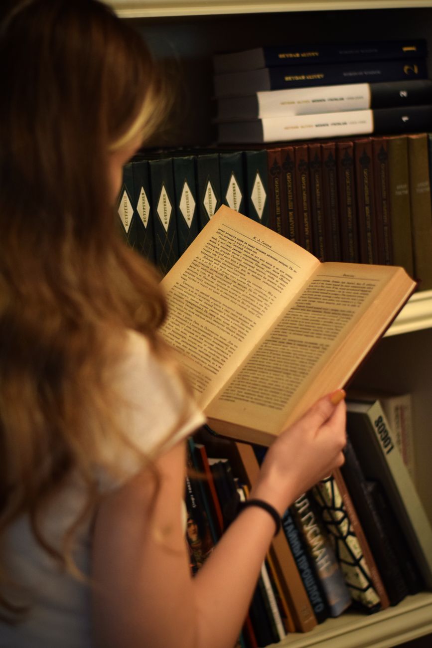 Travel curator studying antique cartography and natural landscape books