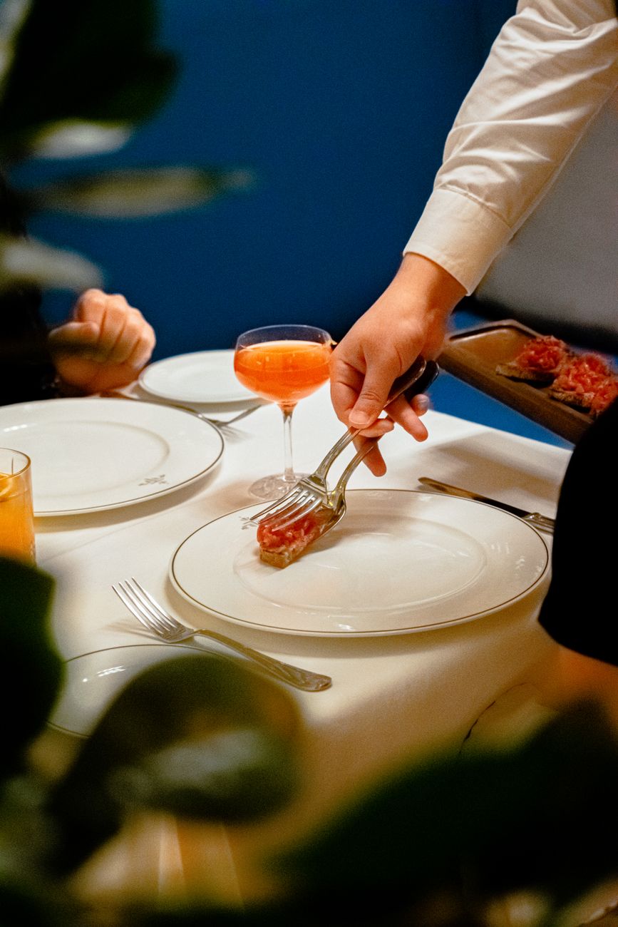 Artisan chef preparing heirloom ingredients in an intimate courtyard dining setting